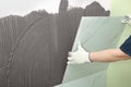 Worker installing ceramic tile on wall, closeup Royalty Free Stock Photo