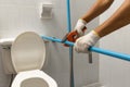 Worker installing floating pipeline on the wall in the old bathroom