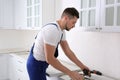 Worker installing furniture in renovated kitchen Royalty Free Stock Photo