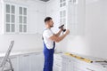 Worker installing handle on cabinet door with screw gun Royalty Free Stock Photo