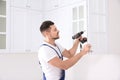 Worker installing handle on cabinet door with screw gun Royalty Free Stock Photo