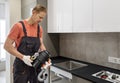 The worker is installing a household waste shredder f Royalty Free Stock Photo