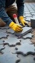 Worker Installing Interlocking Paving Stones with Precision and Specialized Tools