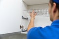 Worker installing kitchen cabinet dish rack Royalty Free Stock Photo
