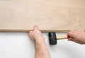 Worker installing laminate floor using a hammer Royalty Free Stock Photo