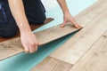 Worker installing new laminated wooden floor. Easy and quick installation of the flooring. Connecting laminate locks. DIY floating Royalty Free Stock Photo