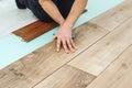 Worker installing new laminated wooden floor. Easy and quick installation of the flooring. Connecting laminate locks Royalty Free Stock Photo