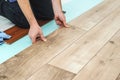 Worker installing new laminated wooden floor. Easy and quick installation of the flooring. Connecting laminate locks Royalty Free Stock Photo