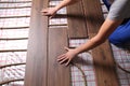 Worker installing new wooden laminate over underfloor heating system, closeup Royalty Free Stock Photo