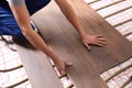 Worker installing new wooden laminate over underfloor heating system, closeup Royalty Free Stock Photo