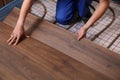 Worker installing new wooden laminate over underfloor heating system Royalty Free Stock Photo