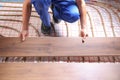 Worker installing new wooden laminate over underfloor heating system Royalty Free Stock Photo