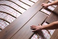 Worker installing new wooden laminate over underfloor heating system, closeup Royalty Free Stock Photo