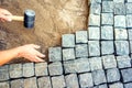 Worker installing pavement rocks, cobblestone blocks on road pavement