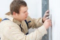 Worker installing power socket in wall Royalty Free Stock Photo