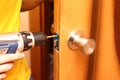 Worker installing or repairing new lock and door knob with screwdriver Royalty Free Stock Photo