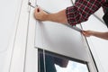 Worker installing roller window blind indoors, closeup Royalty Free Stock Photo