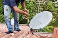 Worker installing satellite dish and antenna on roof top Royalty Free Stock Photo