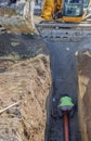 Worker installing sewer pipe in trench 2 Royalty Free Stock Photo