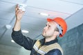 Worker installing smoke detector on the ceiling Royalty Free Stock Photo