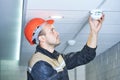 Worker installing smoke detector on the ceiling Royalty Free Stock Photo