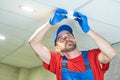 Worker installing smoke detector on the ceiling Royalty Free Stock Photo