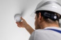 worker installing smoke detector on house ceiling. home security and fire alarm system Royalty Free Stock Photo