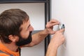 Worker installing socket in new house. Man installing light switch after home renovation Royalty Free Stock Photo