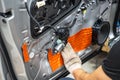Worker installing special acoustic and vibration-damping material for noise insulation on car door. Soundproofing, auto