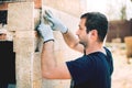 Worker installing stone on architectural facade of new building. details of construction industry Royalty Free Stock Photo