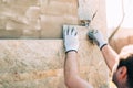 Worker installing stone tiles on wall on construction site