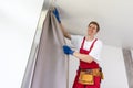 worker installing window curtain rod on the wall