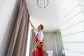 worker installing window curtain rod on the wall