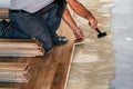 Worker installing wooden flooring boards