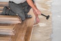 Worker installing wooden flooring boards