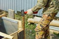 Worker installs formwork, hammer an iron pipe - support Royalty Free Stock Photo