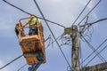 Worker installs new cables on an electric pole