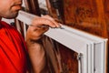 A worker installs new plastic windows in the house, drills holes in the window with a hand-held electric drill. Royalty Free Stock Photo