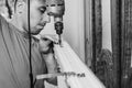 A worker installs new plastic windows in the house, drills holes in the window with a hand-held electric drill. Royalty Free Stock Photo