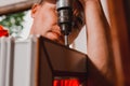 A worker installs new plastic windows in the house, drills holes in the window with a hand-held electric drill Royalty Free Stock Photo