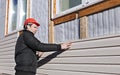 A worker installs panels beige siding on the facade Royalty Free Stock Photo