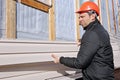 A worker installs panels beige siding on the facade Royalty Free Stock Photo