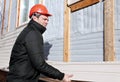 A worker installs panels beige siding on the facade Royalty Free Stock Photo