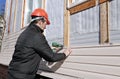 A worker installs panels beige siding on the facade Royalty Free Stock Photo