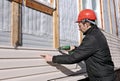 A worker installs panels beige siding on the facade Royalty Free Stock Photo