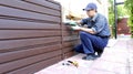 Worker installs plastic siding on the facade