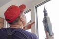 Worker installs windows craftsmen screw frame to the wall Repair in high-rise building