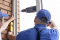 Worker installs windows craftsmen screw frame to the wall Repair in high-rise building