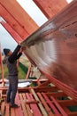 The worker insulates the attic of the house with a hydrofilm, secures the insulation with the help of a stapler