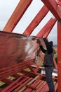 The worker insulates the attic of the house with a hydrofilm, secures the insulation with the help of a stapler